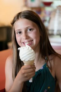 Girl with soft serve ice cream cone at the Dairy Bar at Barnyard Swing, Cooperstown, NY.